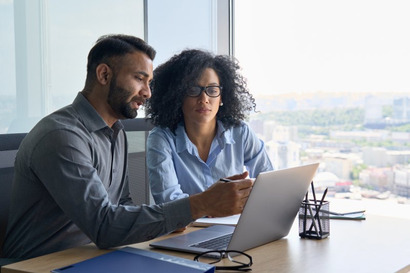 Professionals discussing a software project at a laptop